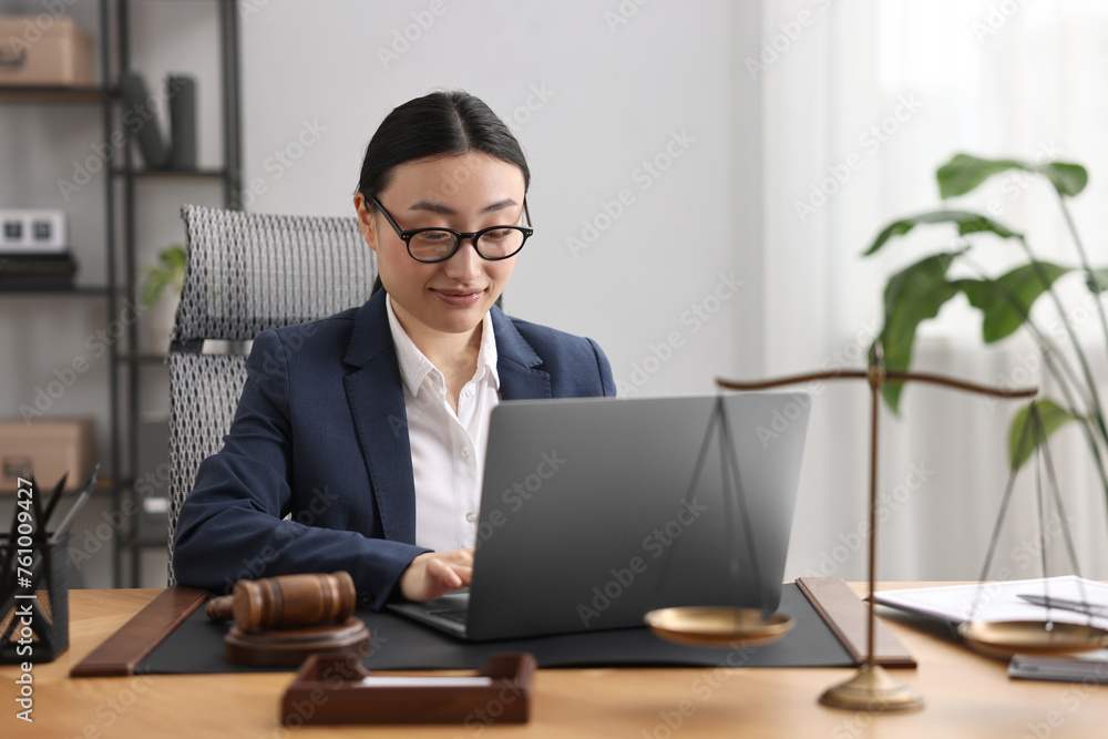 Notary working with laptop at table in office Notary working with laptop at table in office