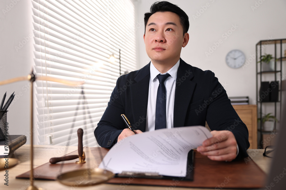 Notary writing notes at wooden table in office Notary writing notes at wooden table in office
