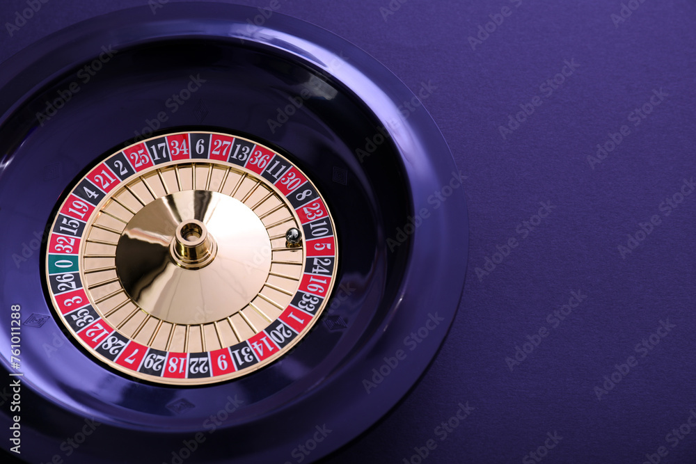 Roulette wheel with ball on dark violet background, top view and space for text. Casino game Roulette wheel with ball on dark violet background, top view and space for text. Casino game