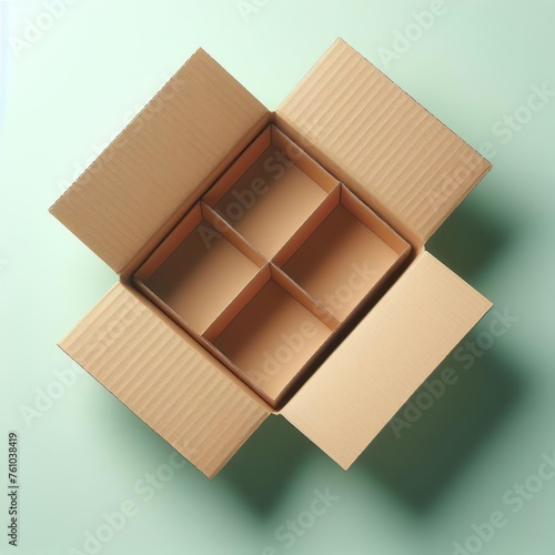 Empty open cardboard box on light green background. Top view.