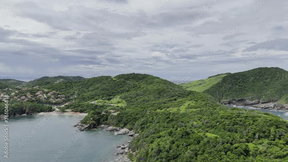 Drone flies up from the sea over a long peninsula toward a hill overlooking beaches and towns in the area Drone flies up from the sea over a long peninsula toward a hill overlooking beaches and towns in the area