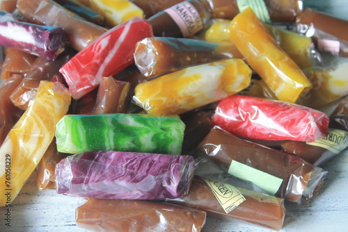 Traditional Indonesian food called jenang with various flavors wrapped in plastic on the table

 photo