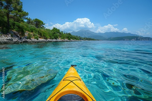 View from a kayak on crystal clear waters with mountains in the distance.