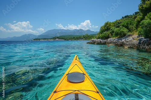 View from a kayak on crystal clear waters with mountains in the distance.