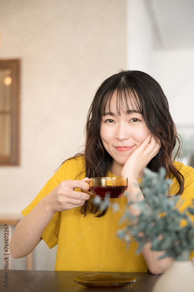 Φωτογραφία カフェや飲食店や自宅お茶を飲むリラックスする美しい女性クローズアップの正面の縦　カメラ目線