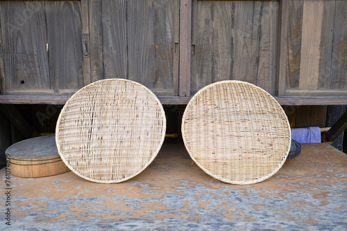 Two Japanese traditional draining baskets made from bamboo being air dried after use outside of a traditional house photo