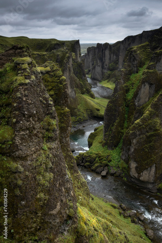 Scenic, mossy Fjadrargljufur canyon in south Iceland during moody overcast day and heavy rain clouds.