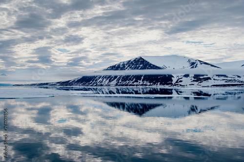 Seascape of cloud reflections awith snow covered mountain in Svalbard
