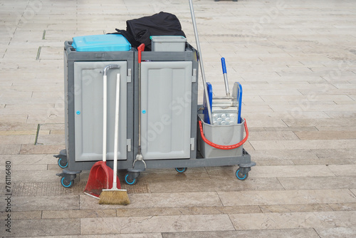 A gaspowered cleaning machine with a rolling cart, broom, and mop photo