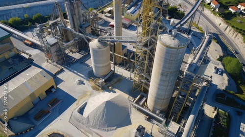 An aerial view of a cement plant with silos, kilns, and conveyors producing cement