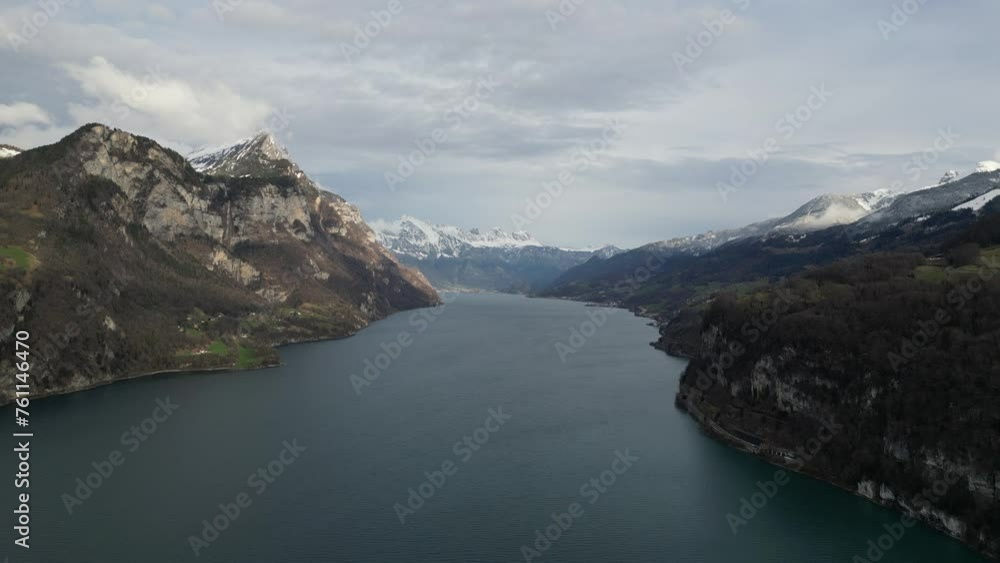 Aerial pan above calm placid lake in Walensee Switzerland above steep cliffs Aerial pan above calm placid lake in Walensee Switzerland above steep cliffs