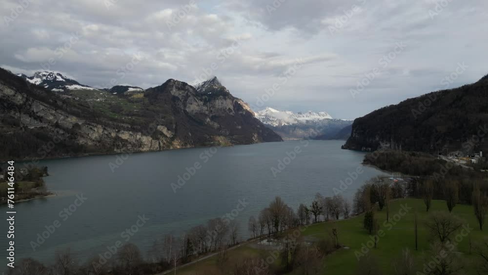Ascend above golf course along shoreline of Lake Walen with swiss mountain peaks in distance Ascend above golf course along shoreline of Lake Walen with swiss mountain peaks in distance