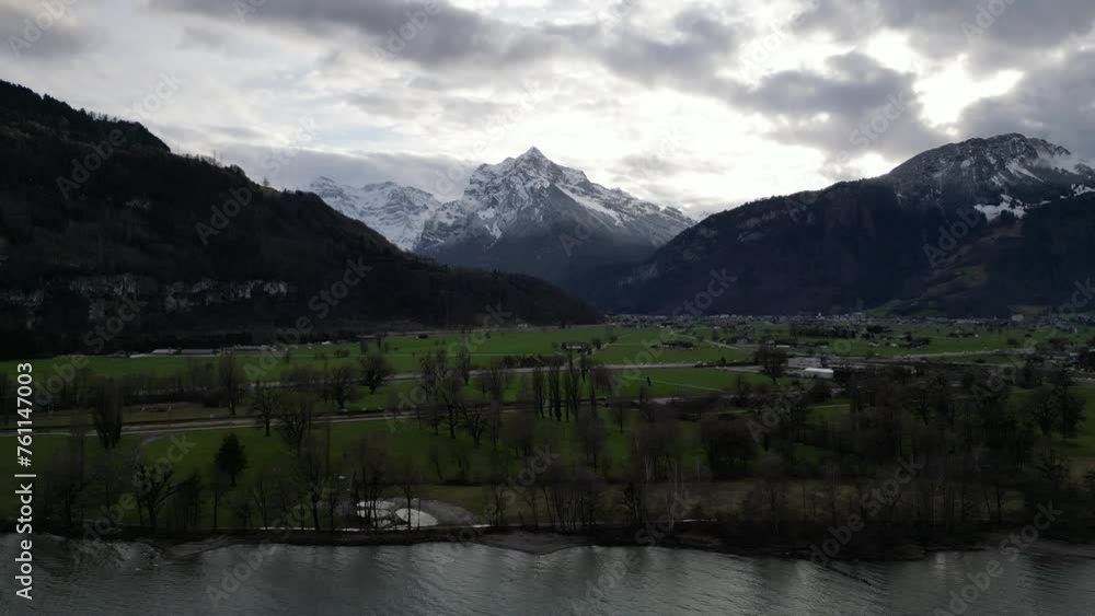 Late afternoon light pierces cloudy sky illuminated mountain peak in distance with grassy fields and light traffic Late afternoon light pierces cloudy sky illuminated mountain peak in distance with grassy fields and light traffic