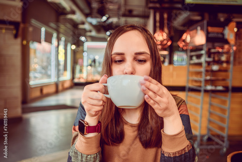 Serene Morning Moment as a Young Woman Sips Coffee in a Cozy Urban coffee shop