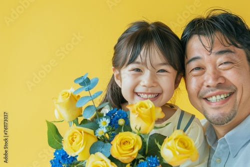 青と黄色の花束を持った、笑顔の子供とお父さん（父の日・father's day・黄色のバラ）