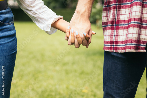 Interracial couple taking a walk hand in hand in the park