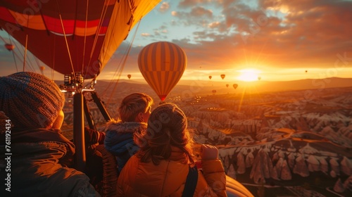  Passengers in a hot air balloon basket enjoy the stunning view of a sunrise surrounded by other balloons, Cappadocia