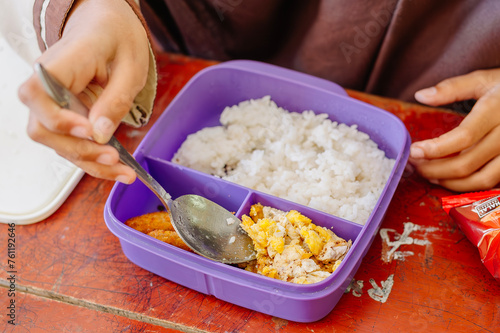 The packed lunch that is being enjoyed by elementary school students, consists of rice, omelettes and fried nuggets which are so delicious and delicious photo