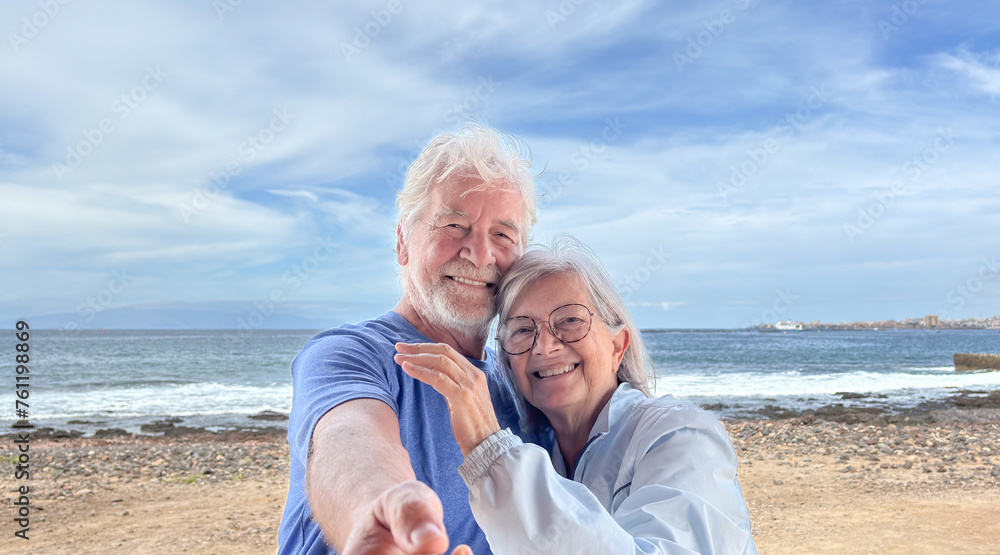 Portrait of senior caucasian couple together in outdoors at the sea beach enjoying vacation and retirement Portrait of senior caucasian couple together in outdoors at the sea beach enjoying vacation and retirement