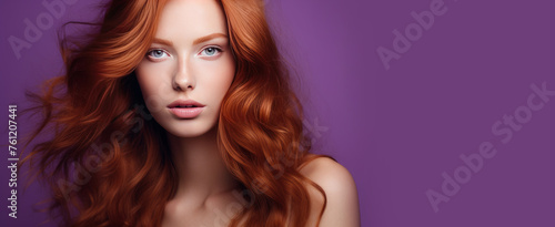 Portrait of an elegant, sexy happy Caucasian woman with perfect skin and red hair, on a purple background, banner.