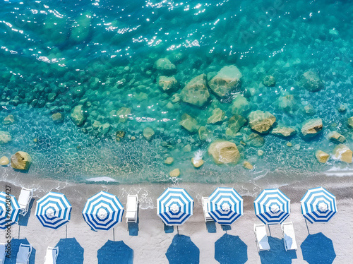 A beach with many blue and white striped umbrellas and sunbeds