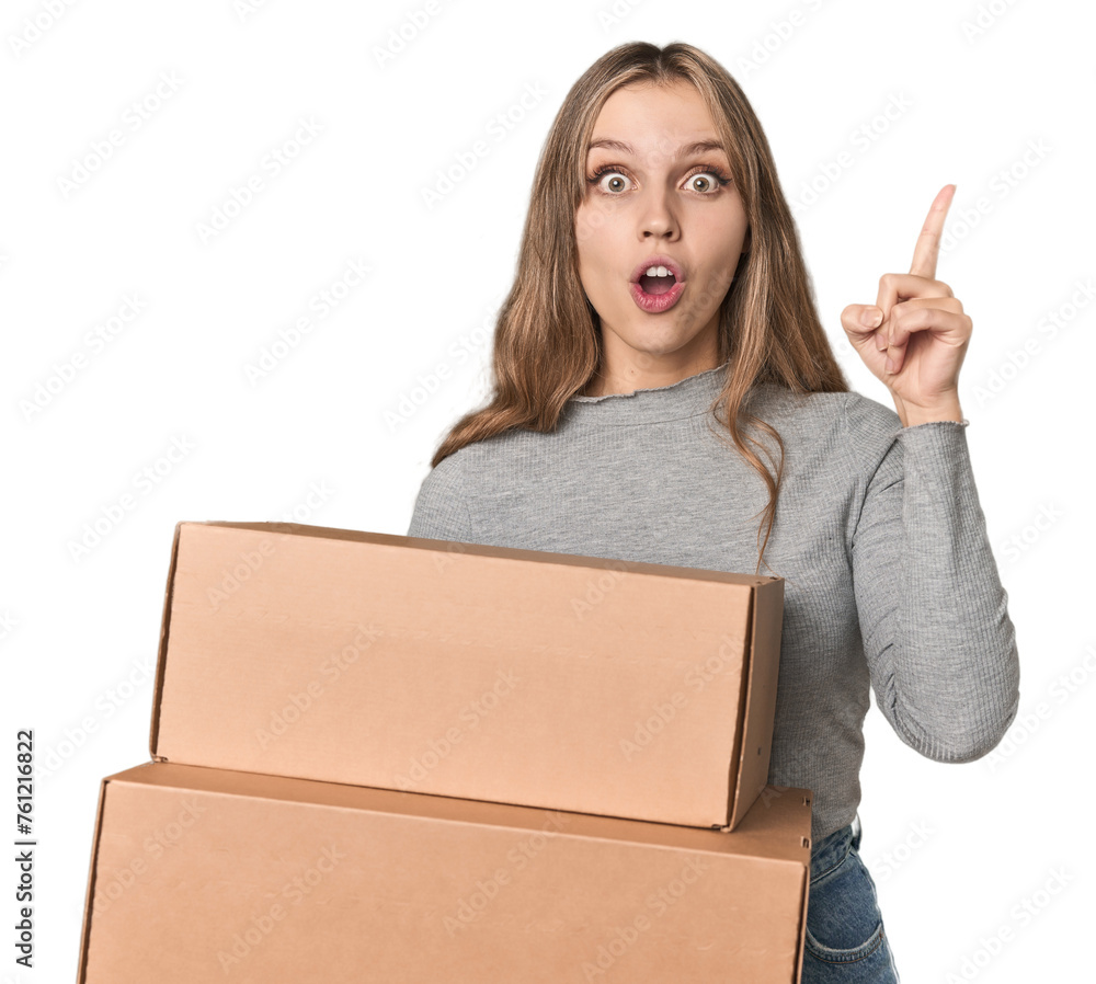 Blonde woman with cardboard boxes moving on studio backdrop having an idea, inspiration concept. Blonde woman with cardboard boxes moving on studio backdrop having an idea, inspiration concept.