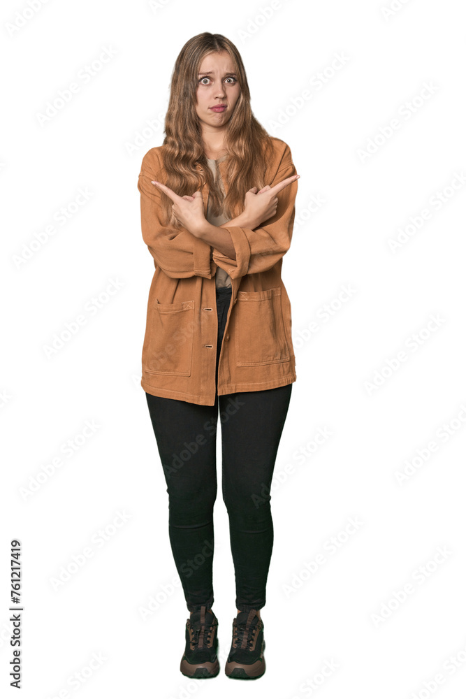 Studio portrait of a blonde Caucasian woman points sideways, is trying to choose between two options. Studio portrait of a blonde Caucasian woman points sideways, is trying to choose between two options.