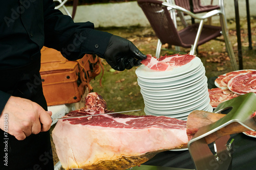 Hands of Master cutter cutting Iberian ham