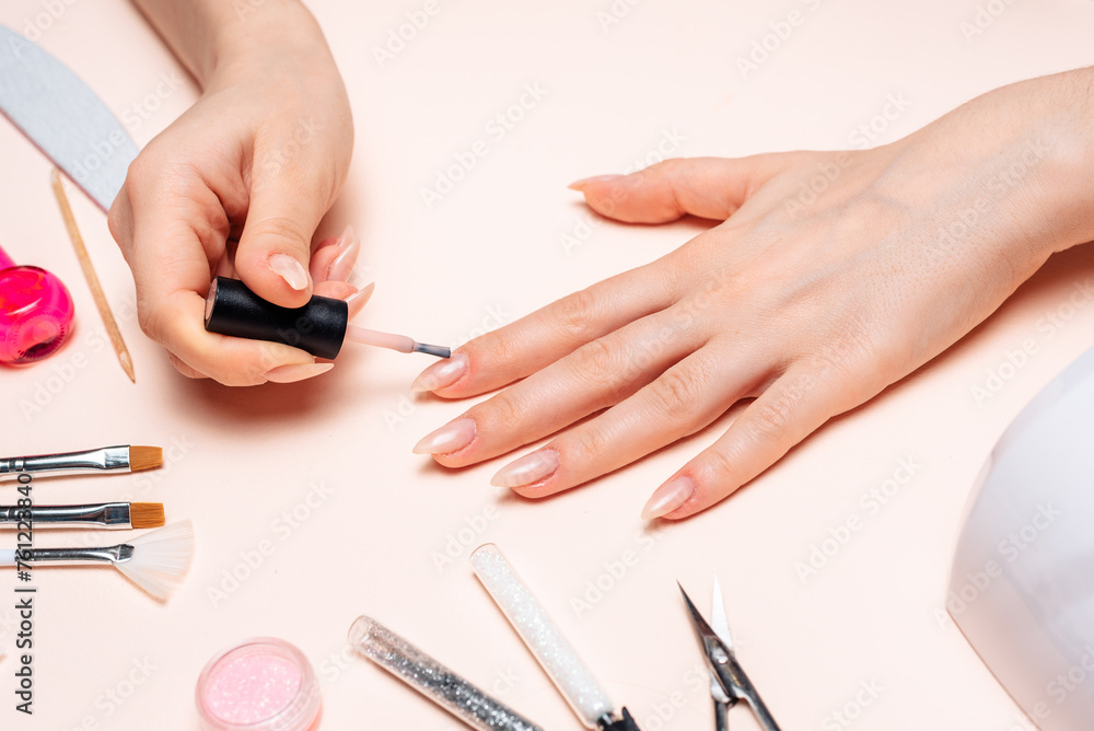Manicure. A girl paints her nails. Hands close up Manicure. A girl paints her nails. Hands close up