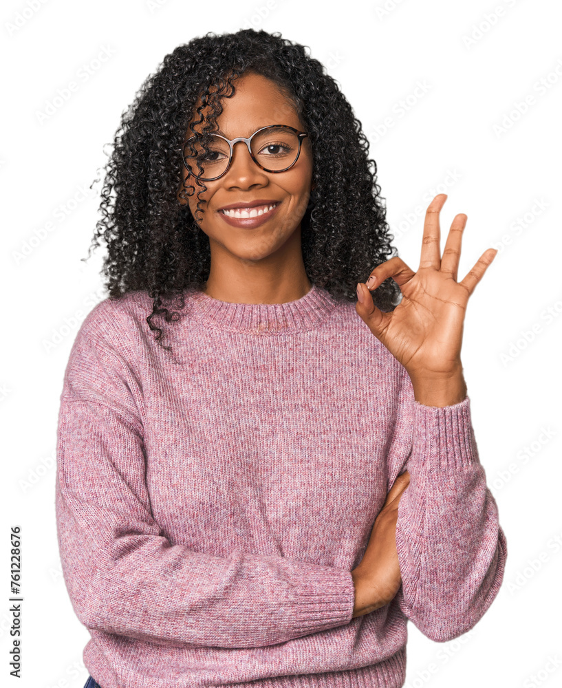 African American woman in studio setting winks an eye and holds an okay gesture with hand. African American woman in studio setting winks an eye and holds an okay gesture with hand.