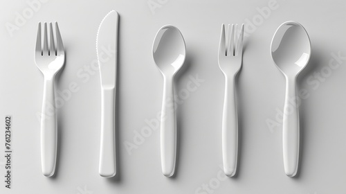The disposable plastic spoon, knife, and fork are modern illustrations on a white background. White plastic party or picnic tableware icons are realistically illustrated on a white background.
