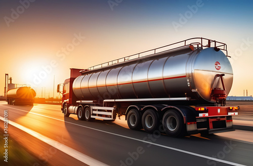 A large metal gasoline tanker with fuel is moving towards a fuel tank