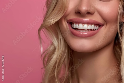 Photo with space for text. Close-up of blonde woman with smile and white teeth on pink
  background. Suitable for advertising toothpaste or dental services