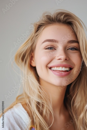 Photo with space for text. Portrait of a blonde woman with a smile and white teeth on a white background. Suitable for advertising