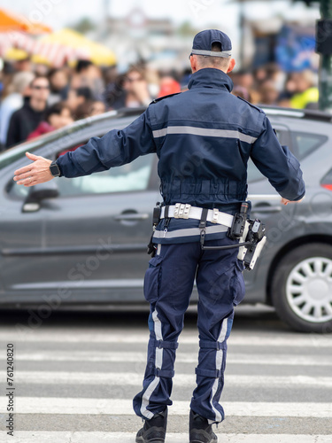 An Italian municipal policeman gestures towards traffic with polizia municipale on his uniform.Italy - Image-
