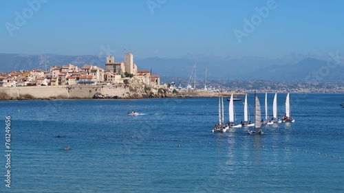 Paysage de côte avec les bateaux d’une école de voile naviguant en mer Méditerranée, dans la baie de la ville d’Antibes, sur la côte d’azur, dans les Alpes-Maritimes (France) photo