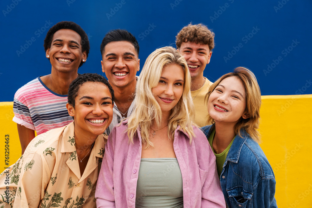 Portrait of laughing multi-ethnic friends against yellow wall Portrait of laughing multi-ethnic friends against yellow wall