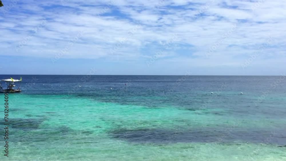 A walk to the popular Salagdoong Beach in Siquijor Island. There is a yellow flag on a pole and a raft floats in the water. The beautiful white sand beach and the crystal clear water in Siquijor. A walk to the popular Salagdoong Beach in Siquijor Island. There is a yellow flag on a pole and a raft floats in the water. The beautiful white sand beach and the crystal clear water in Siquijor.