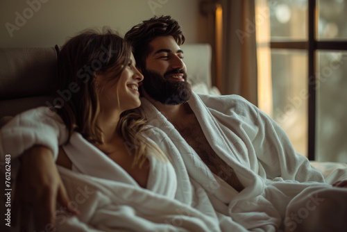 Happy young couple in bathrobes enjoying a romantic moment at a spa hotel