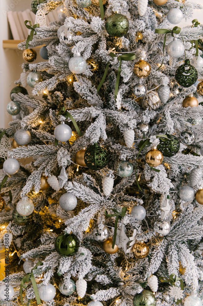Christmas decor, beautiful snow-covered Christmas tree with toys and lights