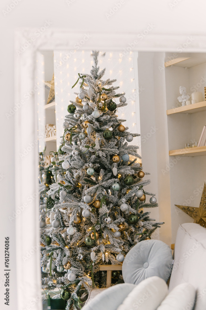 Christmas decor, beautiful snow-covered Christmas tree with toys and lights