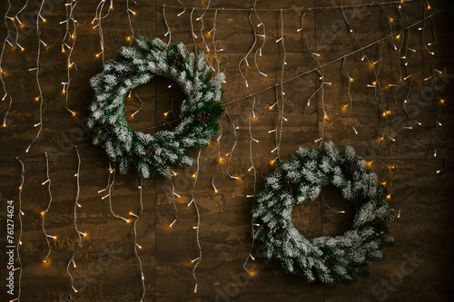 Obraz na płótnie New Year wreaths with lights on a wooden wall background, New Year decor w salonie