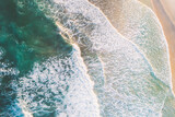 shore of a beach at sunrise, aerial top view with drone
