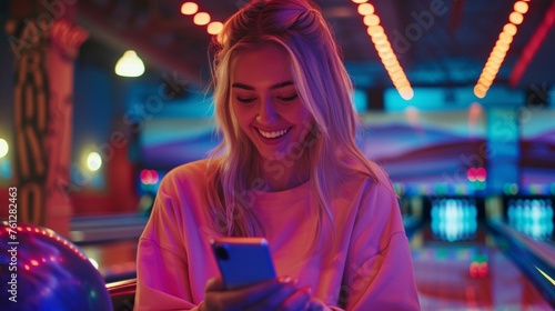 Stylish Blonde Woman Chatting on Smartphone: Nighttime Bowling Fun