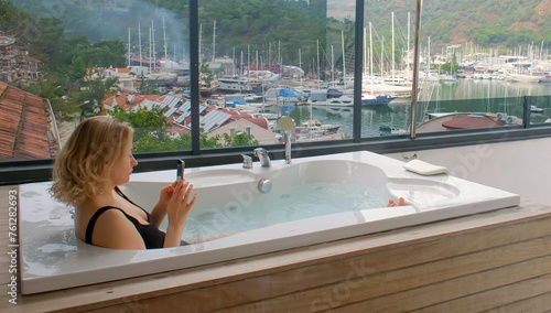 Young women chilling in outdoor hot tub. Luxury leisure activity in sea town