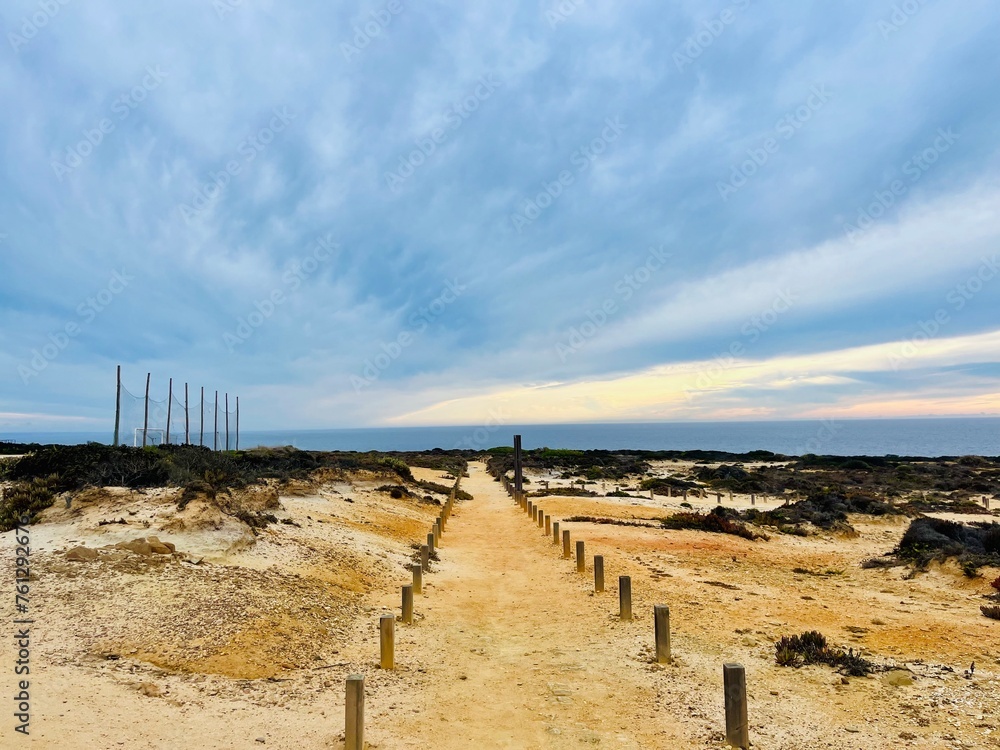 Cloudy sunset at the ocean, rocky ocean coast, sunset ocean horizon, way to the ocean Cloudy sunset at the ocean, rocky ocean coast, sunset ocean horizon, way to the ocean
