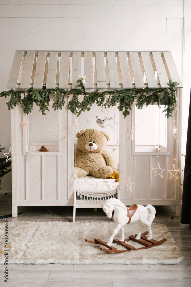 Beautiful stylish modern interior of a children's room with a wooden bed and a toy decorated for the new year