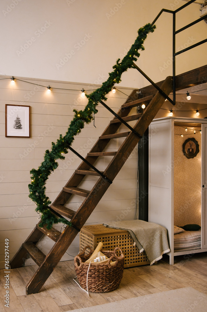 Interior design of a duplex apartment with a metal staircase decorated for the new year