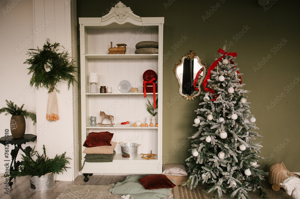 Stylish interior with a white sideboard and a Christmas tree decorated for the new year