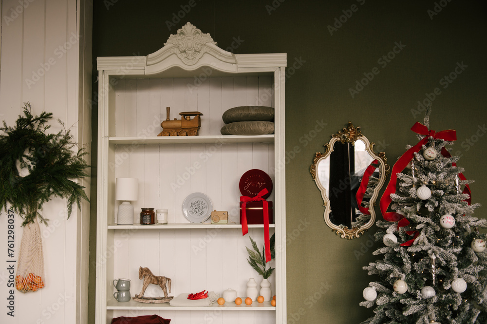 Stylish interior with a white sideboard and a Christmas tree decorated for the new year